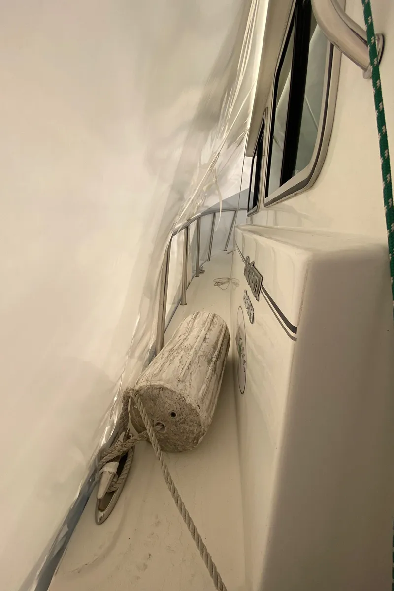 Slide: The Image of 2018 Parker 2530 Extended Cabin boat under cover, side view with fender and rope. - 8