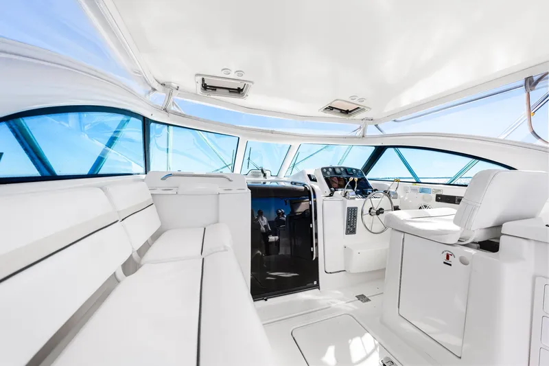 Slide: The Image of Interior of 2002 Pursuit 3800 Express yacht, featuring sleek white seating and modern controls. - 18