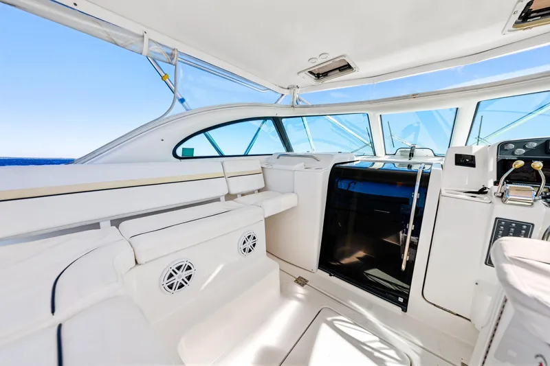 Slide: The Image of 2002 Pursuit 3800 Express yacht interior with white seating and modern controls. - 21