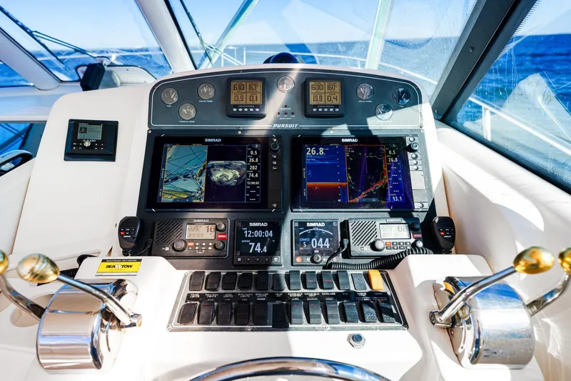 Slide: The Image of Control panel of a 2002 Pursuit 3800 Express boat with navigation screens and controls. - 27