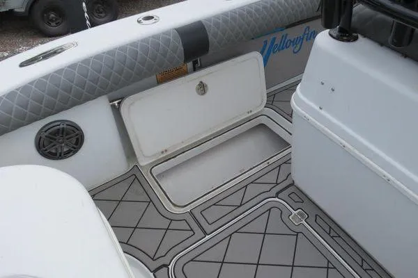 Slide: The Image of Interior of a 2003 Yellowfin 23 Offshore boat, featuring storage compartment and speaker. - 16