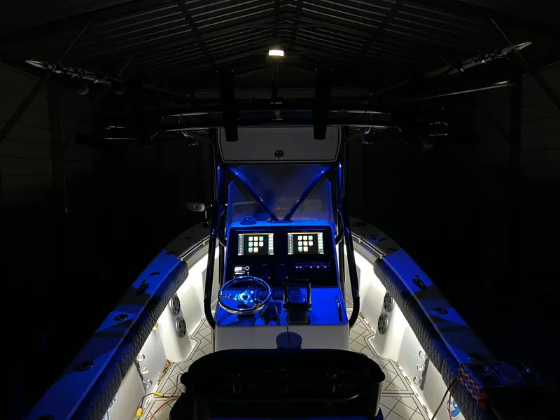 Slide: The Image of 2003 Yellowfin 23 Offshore boat interior with illuminated dashboard and blue accent lighting. - 24