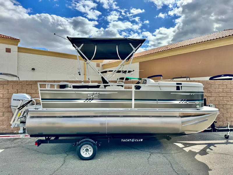 The Image of 2025 Berkshire 18 CR SE pontoon boat on trailer, under a partly cloudy sky. - 0