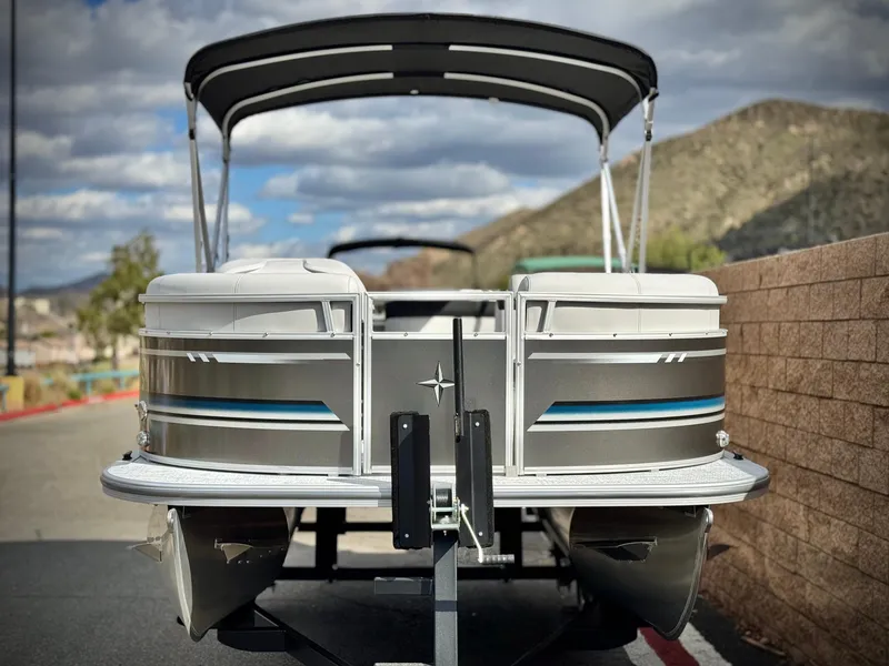 Slide: The Image of 2025 Berkshire 18 CR SE pontoon boat on trailer, scenic mountain backdrop. - 2