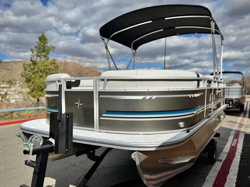 Slide: The Image of 2025 Berkshire 18 CR SE pontoon boat on trailer, under cloudy sky. - 3