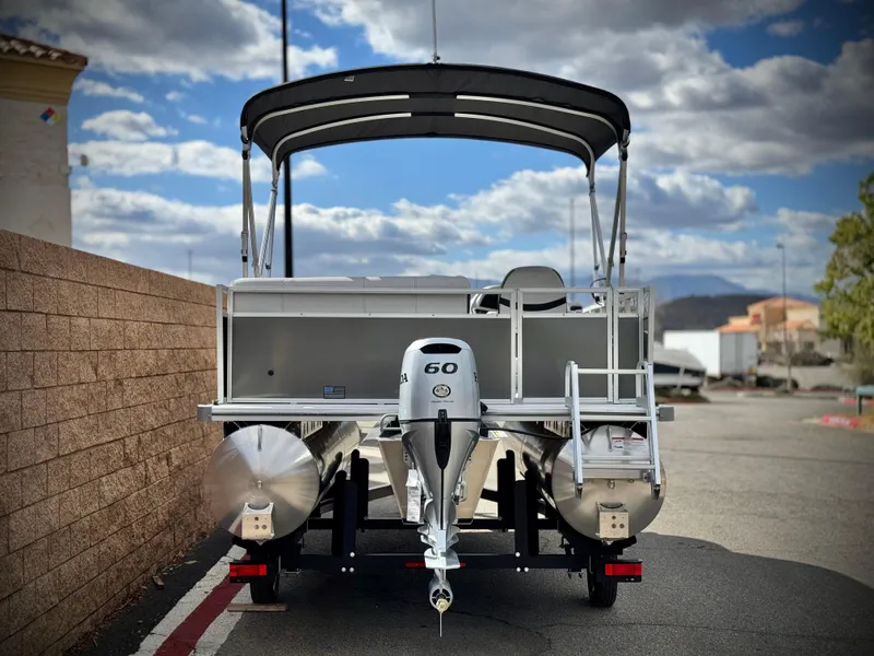 Slide: The Image of 2025 Berkshire 18 CR SE pontoon boat with 60 HP engine, parked outdoors. - 4