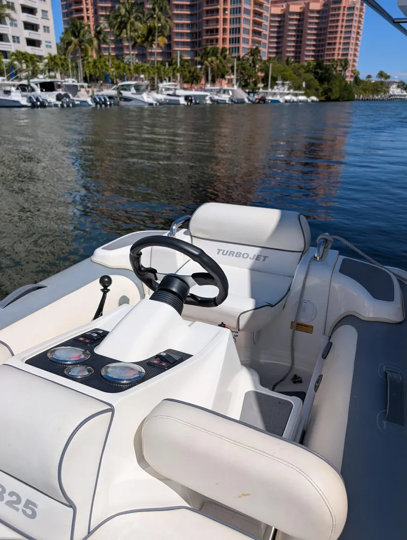 Slide: The Image of 2020 Williams Jet Tenders Turbojet 325 on water, with luxury seating and steering wheel. - 10