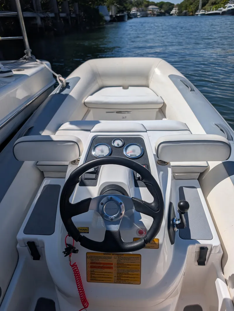 Slide: The Image of 2020 Williams Jet Tenders Turbojet 325, steering console view, docked on a sunny day. - 12