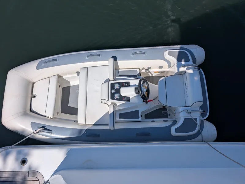 Slide: The Image of 2020 Williams Jet Tenders Turbojet 325, white inflatable boat, docked on calm water. - 7