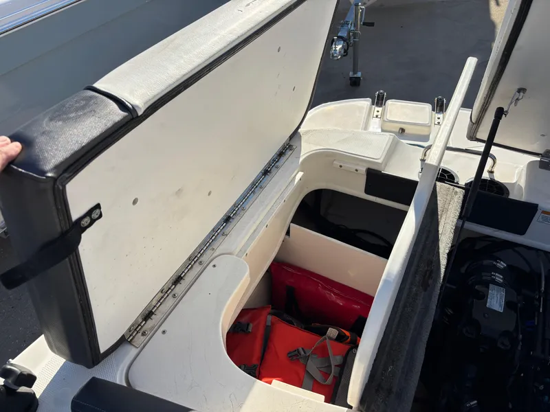 Slide: The Image of Open storage compartment in 2014 Sea Ray 205 Sport boat, showing life jackets inside. - 13