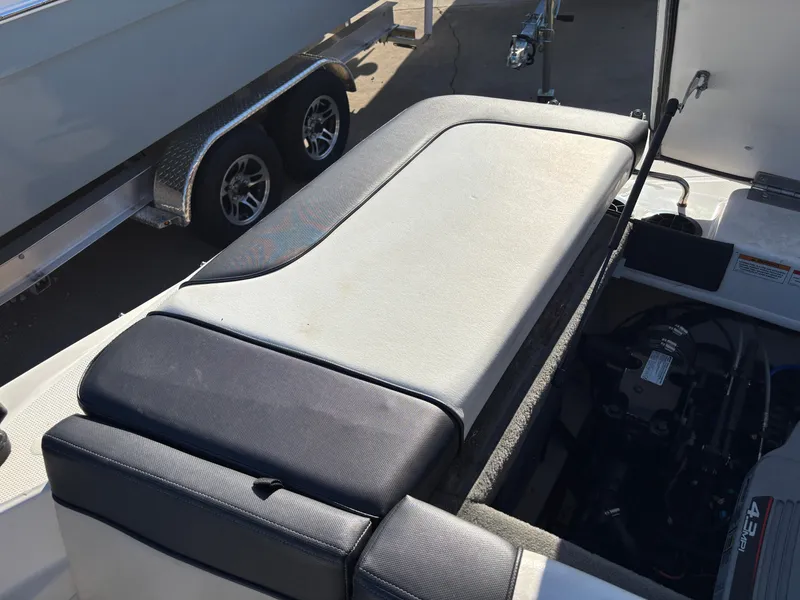 Slide: The Image of 2014 Sea Ray 205 Sport boat interior with cushioned seating and engine compartment. - 15