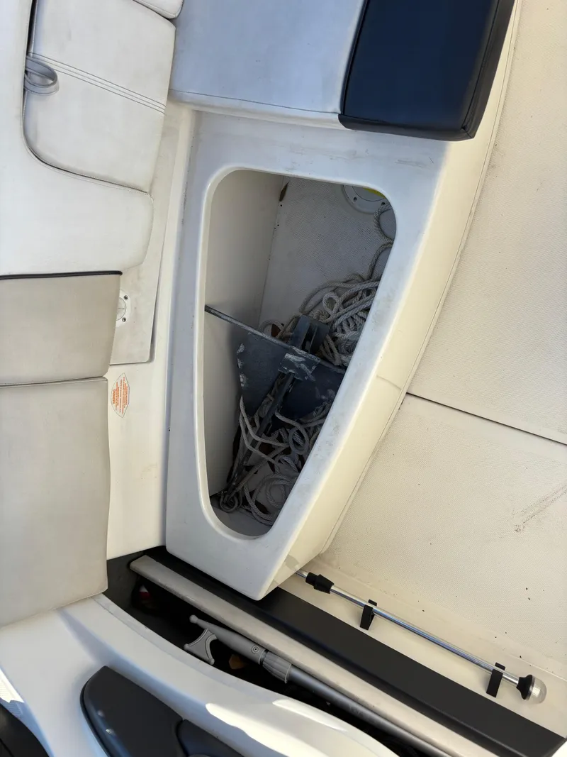 Slide: The Image of 2014 Sea Ray 205 Sport boat interior with storage compartment and ropes. - 28