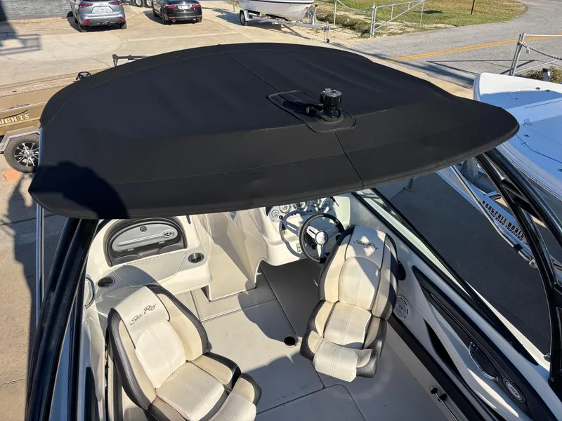 Slide: The Image of 2014 Sea Ray 205 Sport boat interior with black bimini top and beige seating. - 37