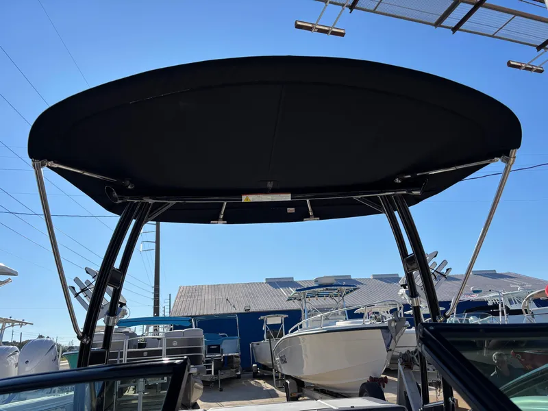 Slide: The Image of 2014 Sea Ray 205 Sport boat with black bimini top in a marina. - 9