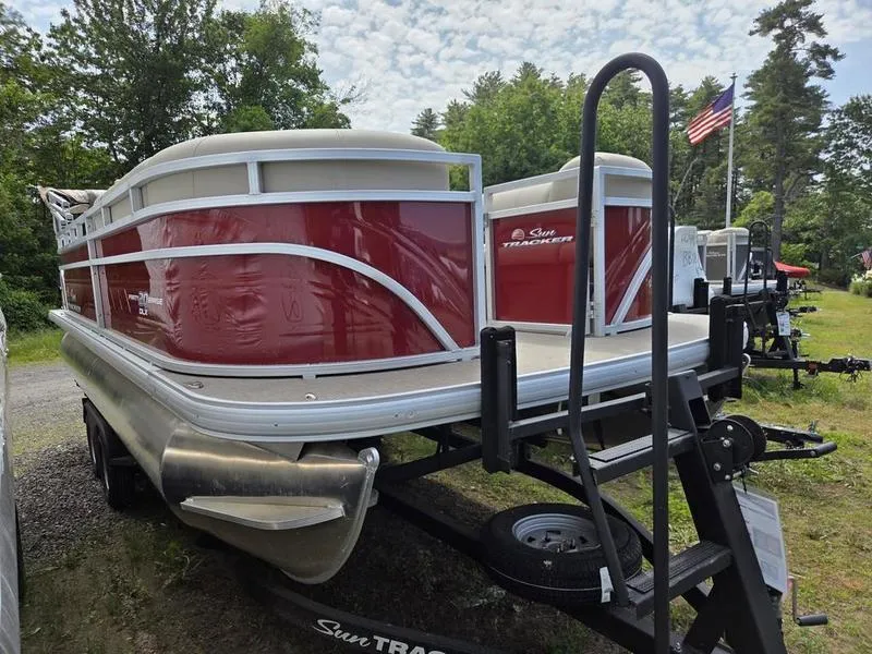 Slide: The Image of 2025 Sun Tracker PB 20 DLX pontoon boat on trailer, parked outdoors. - 11