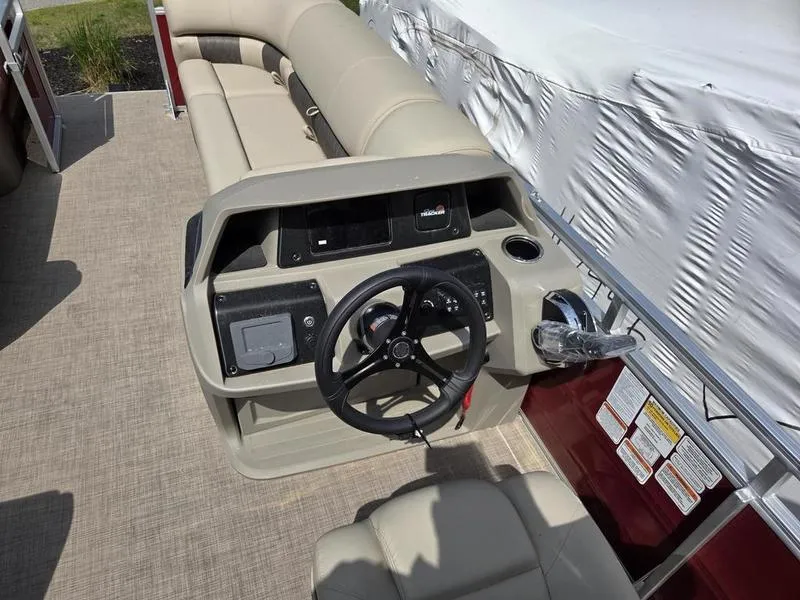 Slide: The Image of 2025 Sun Tracker PB 20 DLX pontoon boat interior with steering console and seating. - 5