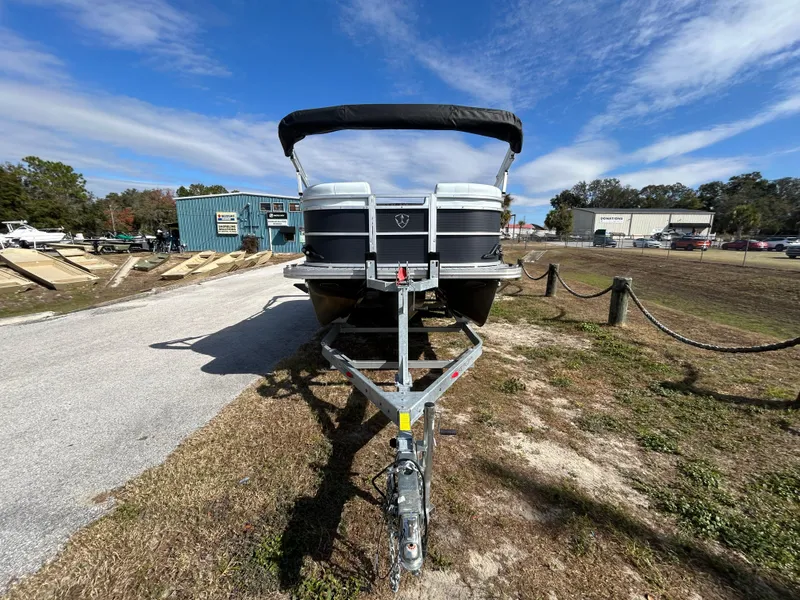 Slide: The Image of 2025 Armada Drakkar K-23SB 3T boat on trailer, parked outdoors under blue sky. - 11