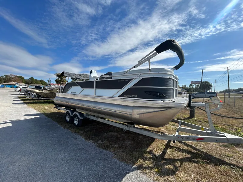 Slide: The Image of 2025 Armada Drakkar K-23SB 3T pontoon boat on trailer under clear sky. - 14