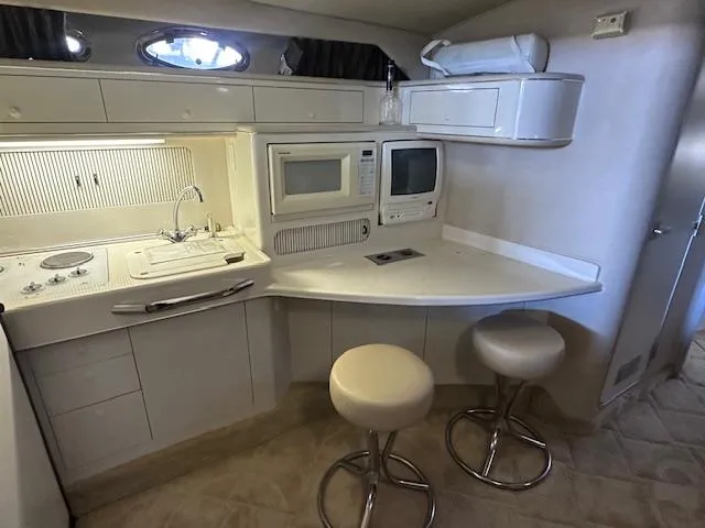Slide: The Image of Interior of 1996 Sea Ray 400 EXPRESS yacht with kitchen and seating area. - 12