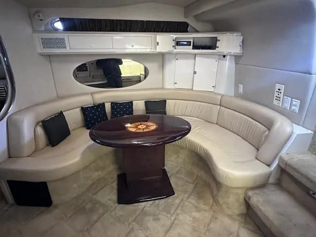 Slide: The Image of Interior of 1996 Sea Ray 400 EXPRESS yacht with curved seating and wooden table. - 13