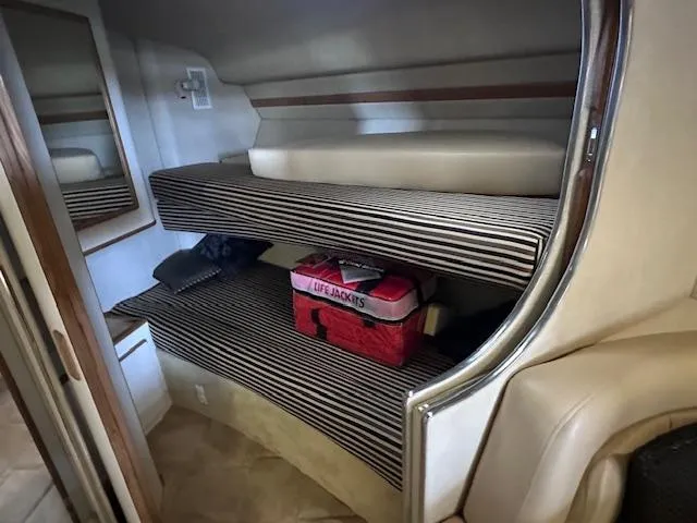 Slide: The Image of Interior cabin of 1996 Sea Ray 400 EXPRESS with striped bunk beds and storage. - 14
