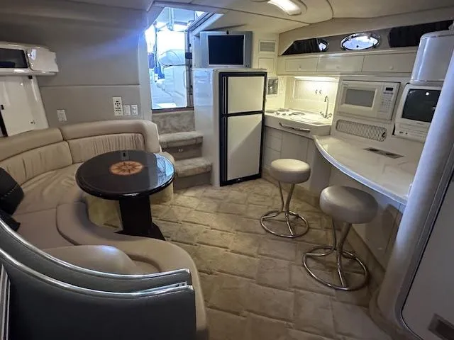 Slide: The Image of 1996 Sea Ray 400 EXPRESS yacht interior with seating, kitchenette, and modern amenities. - 15