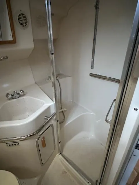 Slide: The Image of 1996 Sea Ray 400 EXPRESS bathroom with shower, sink, and chrome fixtures. - 17