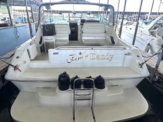 Slide: The Image of 1996 Sea Ray 400 EXPRESS yacht docked, featuring spacious seating and "Fine's Dandy" nameplate. - 4