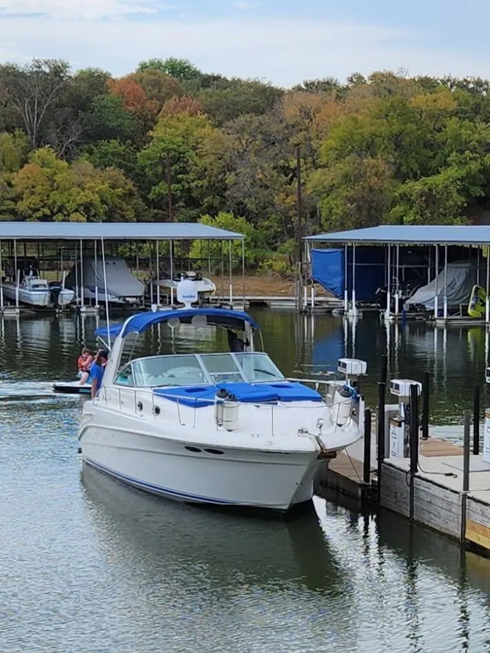 Slide: The Image of 1996 Sea Ray 400 EXPRESS yacht docked at a marina with lush trees in the background. - 5