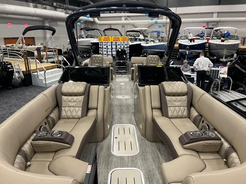 Slide: The Image of 2025 Bennington Q Line luxury boat interior with plush seating at a boat show. - 3