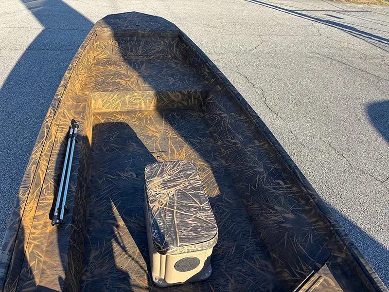 Slide: The Image of 2025 G3 Gator Tough 16 FL boat with camouflage interior on pavement. - 10