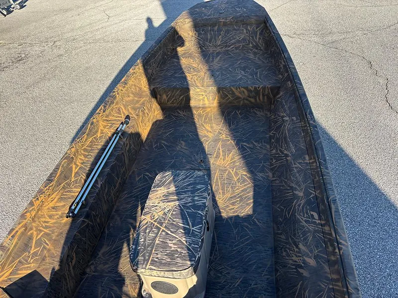 Slide: The Image of 2025 G3 Gator Tough 16 FL boat with camouflage interior on pavement. - 9