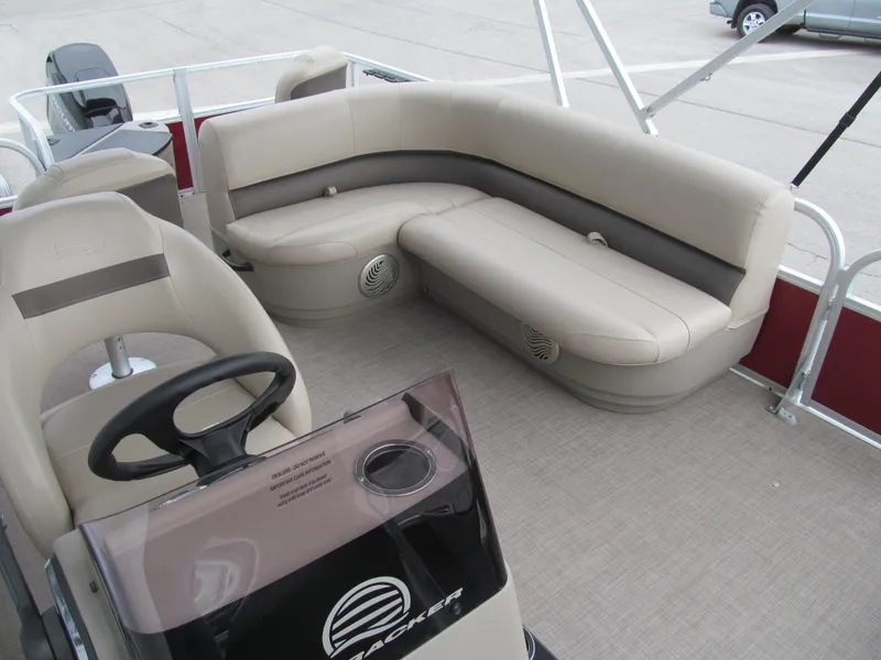 Slide: The Image of 2022 Sun Tracker Bass Buggy 18 DLX pontoon boat interior with beige seating and steering console. - 10