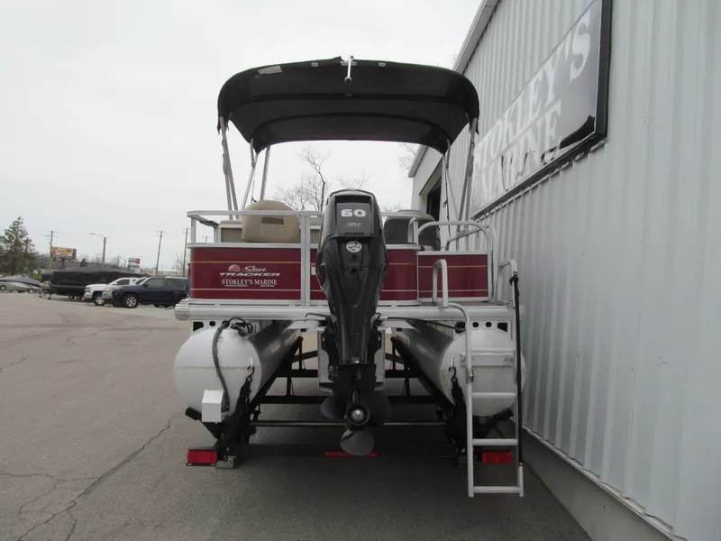 Slide: The Image of 2022 Sun Tracker Bass Buggy 18 DLX pontoon boat with canopy and motor, parked outside. - 3