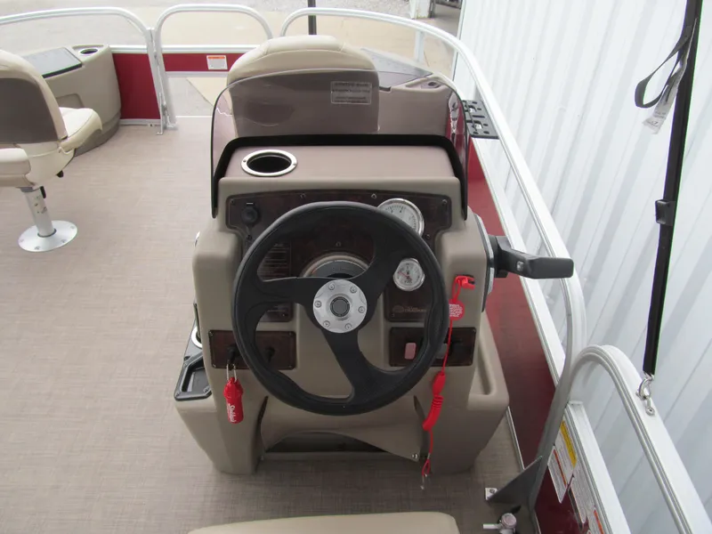 Slide: The Image of 2022 Sun Tracker Bass Buggy 18 DLX steering console with controls and seating. - 5