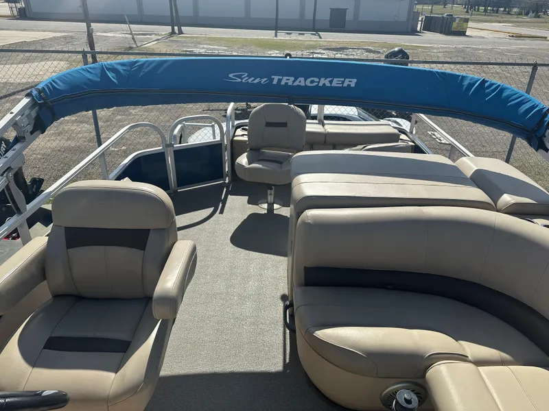 Slide: The Image of 2017 Sun Tracker Fishin' Barge 22 DLX pontoon boat with beige seating and blue canopy. - 6
