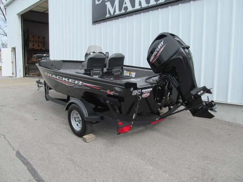 Slide: The Image of 2024 Tracker Super Guide V-16 SC boat with Mercury outboard motor, parked outside a marina. - 3
