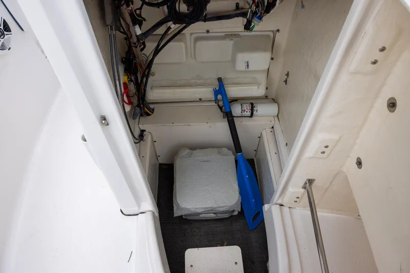 Slide: The Image of 2019 Robalo R180 Center Console storage area with paddle and fire extinguisher. - 10