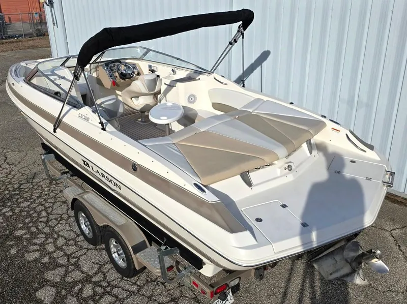 Slide: The Image of 2006 Larson LXI 268 BR boat on trailer, featuring beige and white seating. - 1