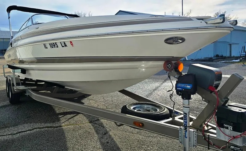 Slide: The Image of 2006 Larson LXI 268 BR boat on trailer, parked outdoors. - 10