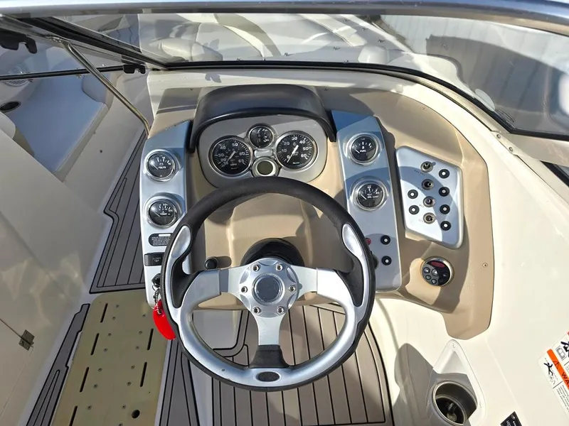 Slide: The Image of 2006 Larson LXI 268 BR boat dashboard with steering wheel and control gauges. - 16