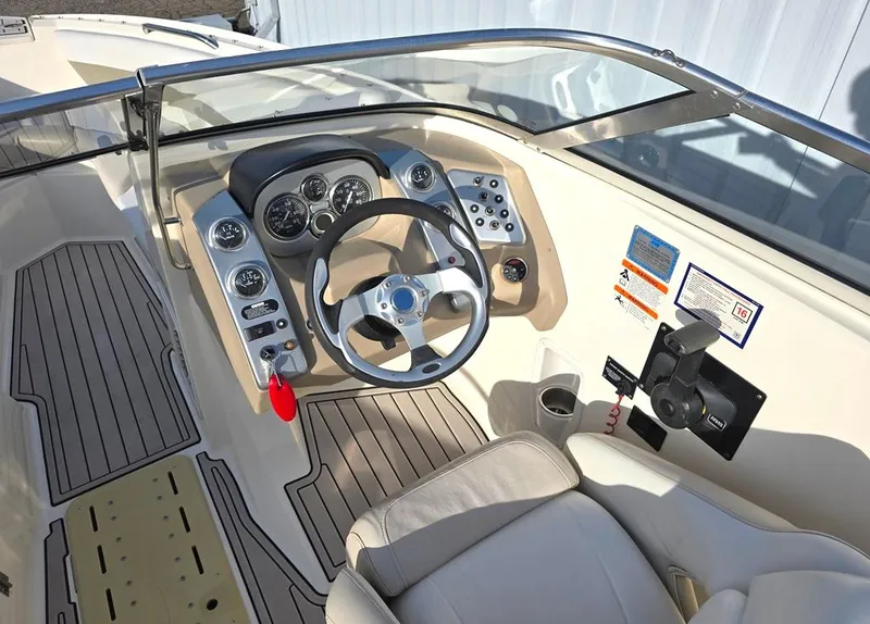 Slide: The Image of 2006 Larson LXI 268 BR boat cockpit with steering wheel and control panel. - 2
