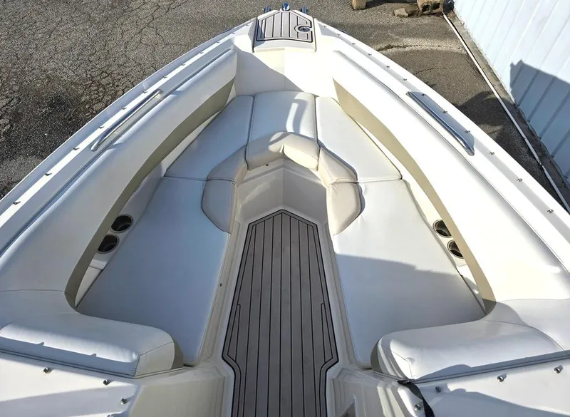 Slide: The Image of 2006 Larson LXI 268 BR boat interior with white seating and wood flooring. - 3