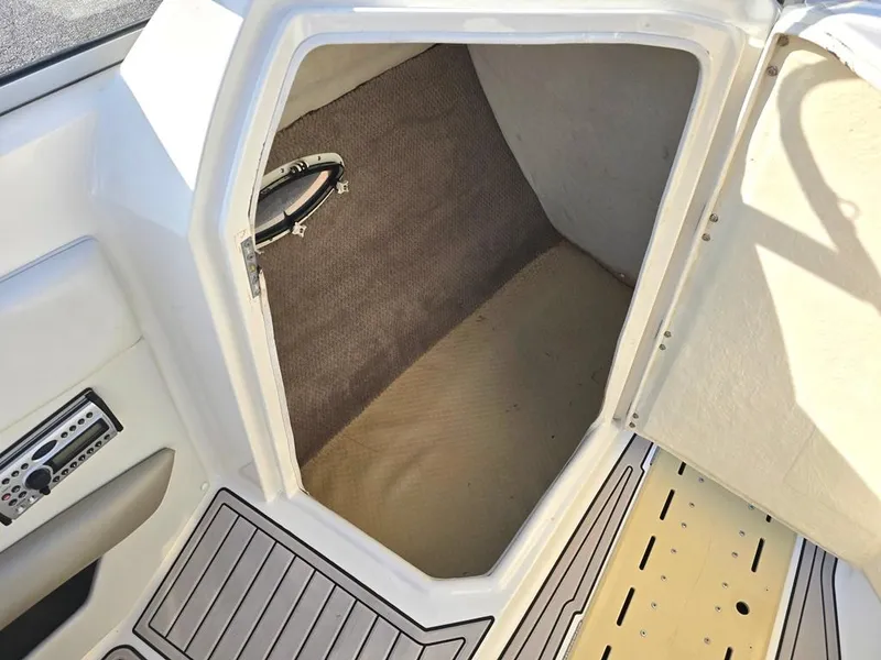 Slide: The Image of 2006 Larson LXI 268 BR boat storage compartment with carpeted interior and stereo system. - 6