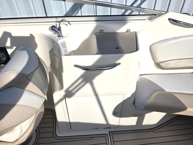 Slide: The Image of Interior of a 2006 Larson LXI 268 BR boat featuring a sink and seating area. - 7