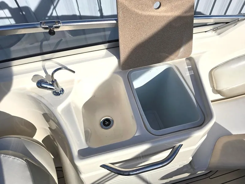 Slide: The Image of 2006 Larson LXI 268 BR boat sink and cooler area with faucet and storage. - 8