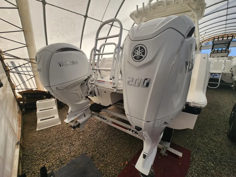 Slide: The Image of 2025 World Cat 260 DC-X boat with dual Yamaha outboard engines in a covered storage area. - 10