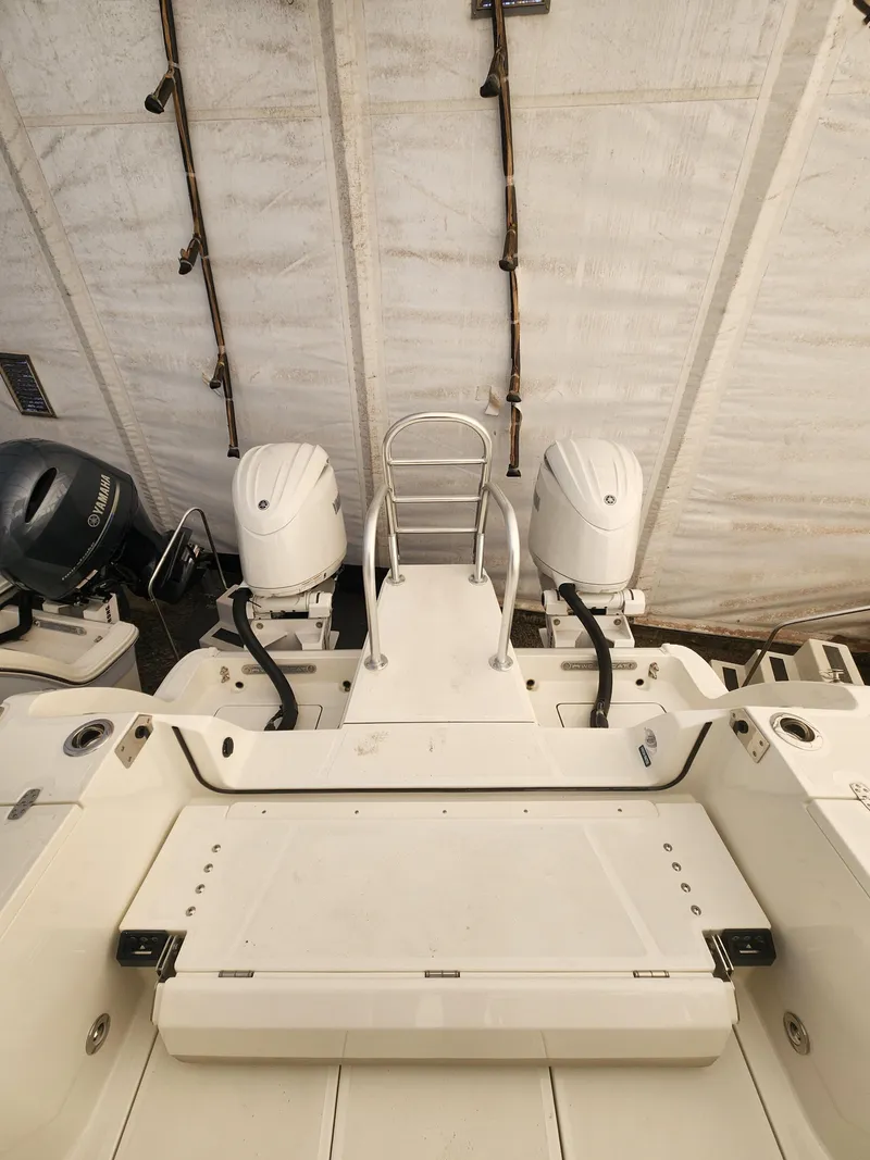 Slide: The Image of 2025 World Cat 260 DC-X boat with dual outboard motors in storage. - 13