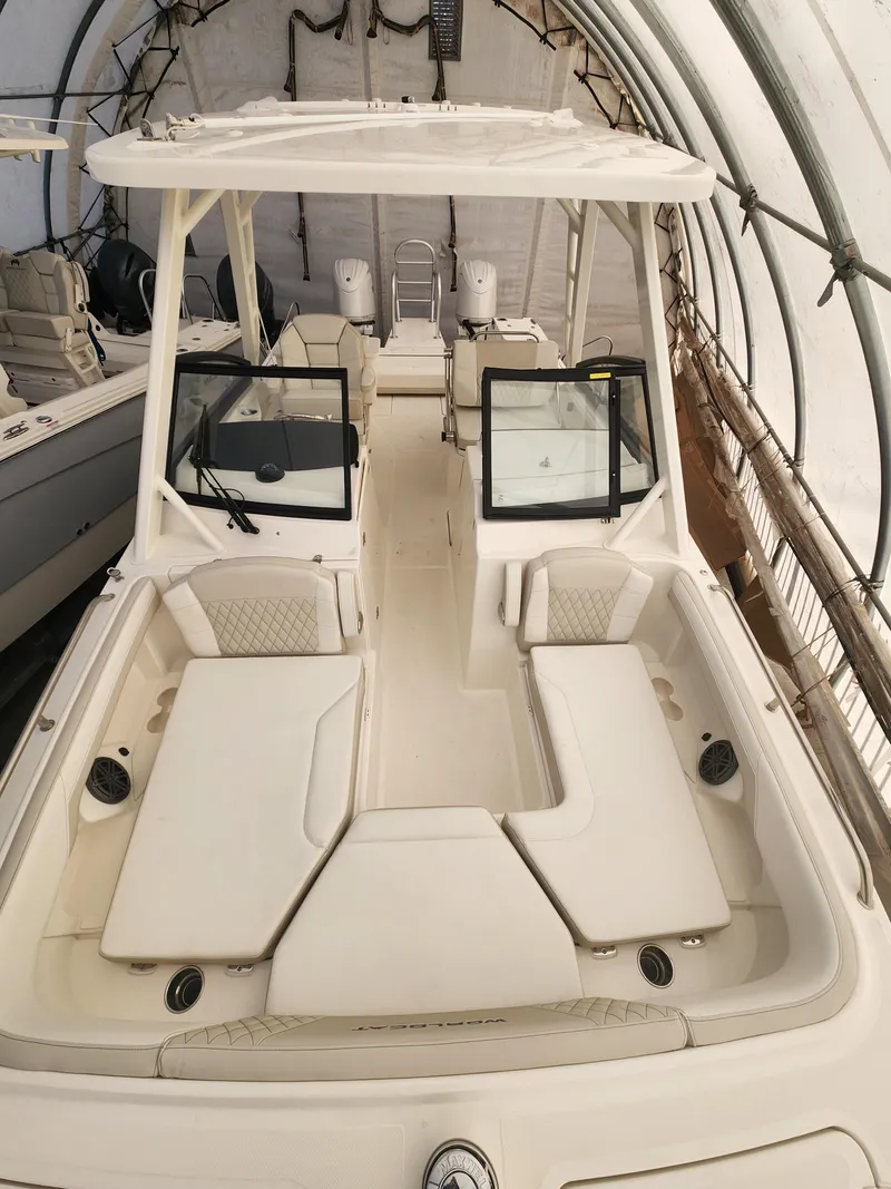 Slide: The Image of 2025 World Cat 260 DC-X boat interior with seating and helm, in storage. - 2
