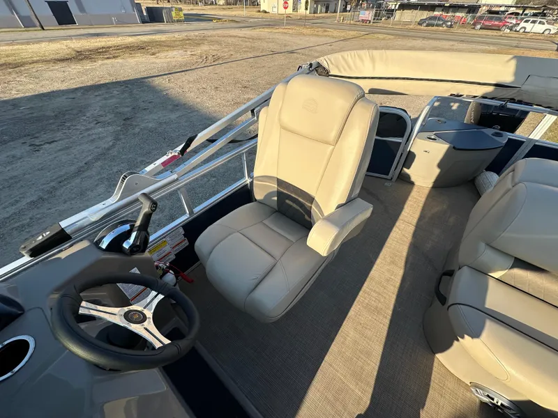 Slide: The Image of 2023 Sun Tracker Fishin' Barge 20 DLX interior with beige seating and steering wheel. - 17